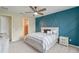 Bedroom with a blue accent wall, plush bedding, and a ceiling fan with great light and style at 9763 Brown Burrow St, Orlando, FL 32829