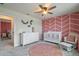 Bright Bedroom with a pink accent wall, white furniture, round pink rug, and floral accents offers a cozy space at 9763 Brown Burrow St, Orlando, FL 32829