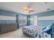 Comfortable bedroom featuring blue and white walls, a plush bed with patterned bedding and soft natural light at 9763 Brown Burrow St, Orlando, FL 32829