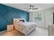 Cozy bedroom featuring a blue accent wall with geometric design, plush bedding, and soft natural light at 9763 Brown Burrow St, Orlando, FL 32829