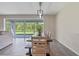 Dining area with modern light fixture, a large wooden table, and sliding glass doors that provide natural light at 9763 Brown Burrow St, Orlando, FL 32829
