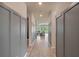 Hallway featuring modern trim, hardwood flooring, and a view into the living area with large windows at 9763 Brown Burrow St, Orlando, FL 32829