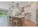 Modern kitchen featuring an island, pendant lights, and an adjacent dining area with exterior view at 9763 Brown Burrow St, Orlando, FL 32829