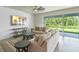 Bright living room featuring neutral furnishings, modern ceiling fan, and sliding glass doors to the outdoor space at 9763 Brown Burrow St, Orlando, FL 32829