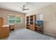 Cozy bedroom with neutral tones, ceiling fan, and a desk with a large window view at 610 Palomas Ave, Ocoee, FL 34761