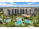 A beautiful aerial view of the resort-style pools surrounded by lush landscaping and multi-story condo buildings at 14501 Grove Resort Ave # 3735, Winter Garden, FL 34787