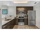 Modern kitchen with stainless steel appliances, sleek cabinets, quartz countertops, and wood grain flooring at 14501 Grove Resort Ave # 3735, Winter Garden, FL 34787