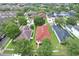 Residential neighborhood with well-manicured lawns and mature trees, showcasing a home with a red roof at 14717 Royal Poinciana Dr, Orlando, FL 32828