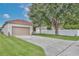 Home exterior featuring a two-car garage, manicured lawn, and concrete driveway at 14717 Royal Poinciana Dr, Orlando, FL 32828