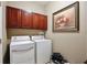 Functional laundry room with upper cabinets and modern white washer and dryer at 14717 Royal Poinciana Dr, Orlando, FL 32828