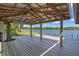 Lake house deck with a metal roof covering, ceiling fan, views of the lake, and wooden beams at 18618 Lake Pickett Rd, Orlando, FL 32820