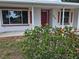 Inviting front porch with decorative brick accents, a red door, and lush landscaping at 217 Longleaf Ct, Orlando, FL 32835