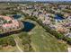 Stunning aerial view of a community with lush golf course, ponds, and residences under a clear blue sky at 5813 Parkview Point Dr, Orlando, FL 32821