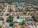 Aerial view showcases the community's layout, highlighting the pool, tennis court, and surrounding residences near a lake at 5813 Parkview Point Dr, Orlando, FL 32821