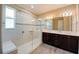 Beautiful bathroom featuring a glass shower with a bench, and double sinks with dark wood cabinets at 611 San Raphael St, Kissimmee, FL 34759