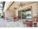 The covered patio featuring ceiling fans and stylish furniture leads to views of the pool and greenery at 611 San Raphael St, Kissimmee, FL 34759