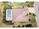 Aerial view showcasing the home's tile roof, screened-in pool, and well-manicured lawn at 611 San Raphael St, Kissimmee, FL 34759