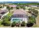 Aerial view highlighting the screened-in pool and lush landscaping surrounding this home at 611 San Raphael St, Kissimmee, FL 34759