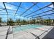 Sparkling pool enclosed in a screened lanai, surrounded by lush landscaping and clear blue skies at 611 San Raphael St, Kissimmee, FL 34759