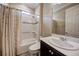 Well lit bathroom with shower tub combo featuring decorative accent tile and dark wood cabinets at 611 San Raphael St, Kissimmee, FL 34759
