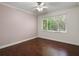 Neutral bedroom with hardwood floors, ceiling fan, and large window with natural light at 8359 Grey Bark Ct, Sanford, FL 32771