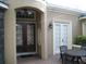 Grand entryway with decorative glass doors, transom window, and a cozy outdoor dining area at 2108 Northumbria Dr, Sanford, FL 32771