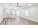 Spacious living room with hardwood flooring, a ceiling fan, and large windows for plenty of natural light at 250 E 20Th Ave, Mount Dora, FL 32757