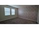 This bedroom features carpeting, two windows, and stylish wallpaper on one wall at 3043 Beaver Creek Dr, Kissimmee, FL 34746