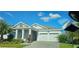 Beautiful single-story home featuring a two-car garage, manicured landscaping, and a gray brick driveway at 3043 Beaver Creek Dr, Kissimmee, FL 34746