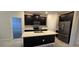 Modern kitchen features dark cabinetry, stainless steel appliances, and a center island with a sink at 3043 Beaver Creek Dr, Kissimmee, FL 34746