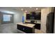 Modern kitchen features dark cabinetry, stainless steel appliances, and a center island with a sink at 3043 Beaver Creek Dr, Kissimmee, FL 34746