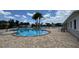 Inviting community pool surrounded by palm trees and comfortable lounge chairs on a sunny day at 3043 Beaver Creek Dr, Kissimmee, FL 34746
