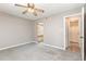 A bedroom featuring neutral walls, carpet, a ceiling fan, and a doorway to an ensuite bathroom at 4060 E Maryland Pl, Casselberry, FL 32707