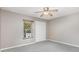 Serene bedroom featuring neutral walls, plush carpeting, and a large window with bright natural light at 4060 E Maryland Pl, Casselberry, FL 32707