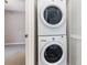 A laundry area with stacked washer and dryer, next to a door leading to another room at 4060 E Maryland Pl, Casselberry, FL 32707