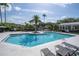 Sparkling community pool surrounded by lounge chairs and lush landscaping at 5136 Park Central Dr # 212, Orlando, FL 32829