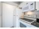 Kitchen featuring essential appliances, white cabinets and a granite countertop at 5136 Park Central Dr # 212, Orlando, FL 32829