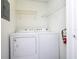 Laundry area with a washer, dryer, and wire shelving for convenient storage solutions at 5136 Park Central Dr # 212, Orlando, FL 32829
