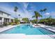 Beautiful community pool surrounded by palm trees and ample lounge seating for relaxation at 5136 Park Central Dr # 212, Orlando, FL 32829