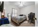 Functional bedroom with a fan, window, work desk, and bed with neutral tones at 8975 Cypresswood Dr, Lake Wales, FL 33898