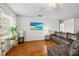 Inviting living room with hardwood floors, a large window, and a comfortable leather sofa at 8975 Cypresswood Dr, Lake Wales, FL 33898