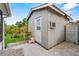 A backyard shed features vertical siding, a white door, and an air conditioning unit for temperature control at 8975 Cypresswood Dr, Lake Wales, FL 33898