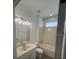 Well-lit bathroom featuring a bathtub/shower combo, white vanity, and tile flooring at 9516 Piccadilly Sky Way, Orlando, FL 32827