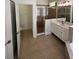 Bright bathroom with a glass shower, tiled floor, and double sink vanity with marble countertop at 9516 Piccadilly Sky Way, Orlando, FL 32827