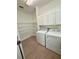 Spacious laundry area features new appliances, built-in shelving and tile flooring at 9516 Piccadilly Sky Way, Orlando, FL 32827