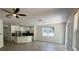 Open-concept living room with wood floors, a ceiling fan, and natural light from a window overlooking the neighborhood at 9516 Piccadilly Sky Way, Orlando, FL 32827