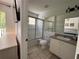 Bright bathroom featuring a shower with glass doors, white toilet and vanity at 1119 Park Ridge Cir, Kissimmee, FL 34746