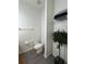 Bright bathroom includes toilet, towel rack and shelf unit with stacked towels at 1119 Park Ridge Cir, Kissimmee, FL 34746