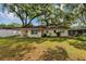 Lush backyard showcasing green grass, shade trees, and a small patio area perfect for outdoor entertaining at 112 E Coleman Cir, Sanford, FL 32773