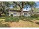 Side yard view of the home surrounded by mature trees, providing natural beauty and plenty of shade at 112 E Coleman Cir, Sanford, FL 32773